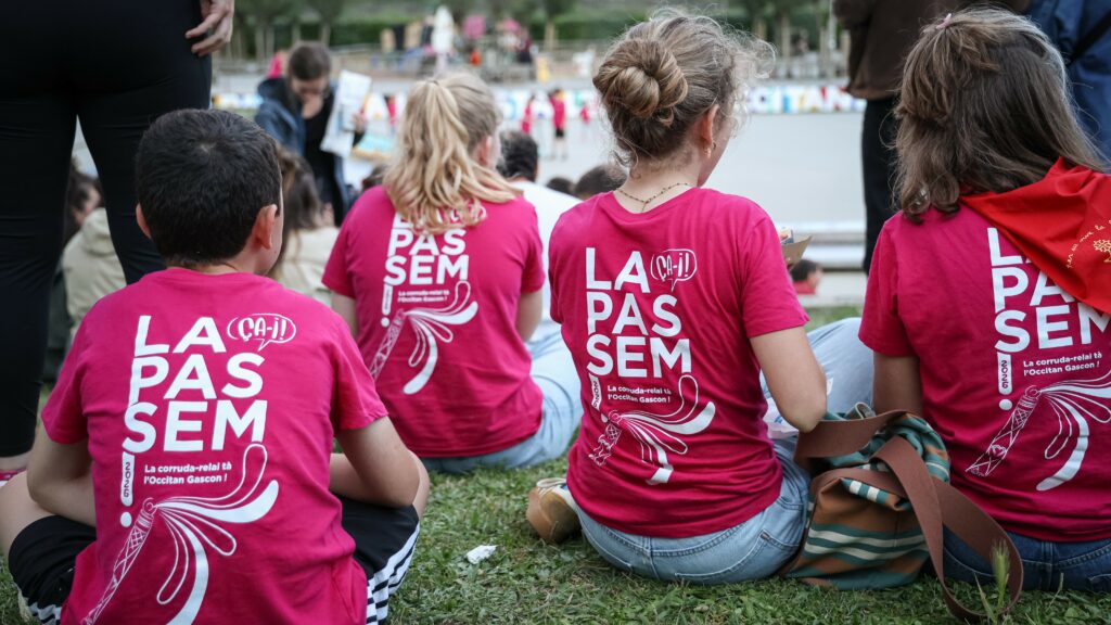 Cette image représente quatre enfants de dos vétus du quesot de La Passem.