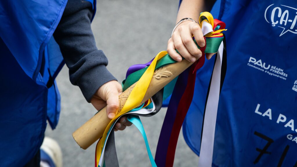 Cette image représente le passage du ligament entre deux enfants dont on ne voit que les mains.